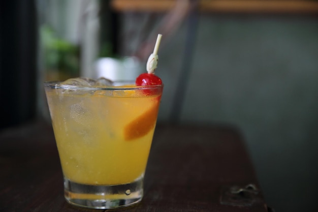 Mai tai cocktail con frutti di ciliegie arancioni su fondo di legno