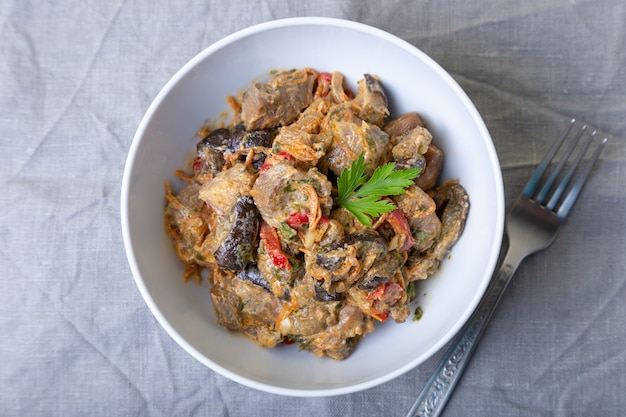 Maiale con melanzane, pomodori, peperoni e carote in salsa cremosa. Avvicinamento.