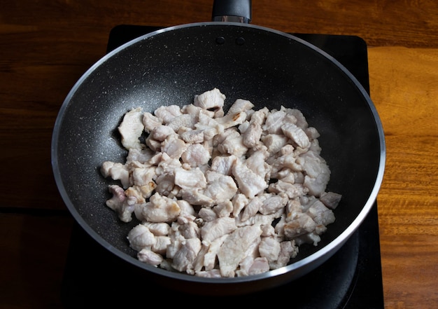 Maiale fritto in una padella calda.