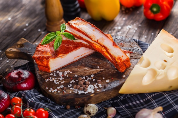 maiale intero e pezzi di peperone speziato, sul tagliere della cucina, scuro e lunatico, clouseup nero