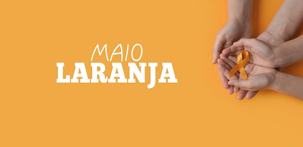 Maio laranja Mani che tengono un nastro arancione Protezione di bambini e adolescenti dalla violenza