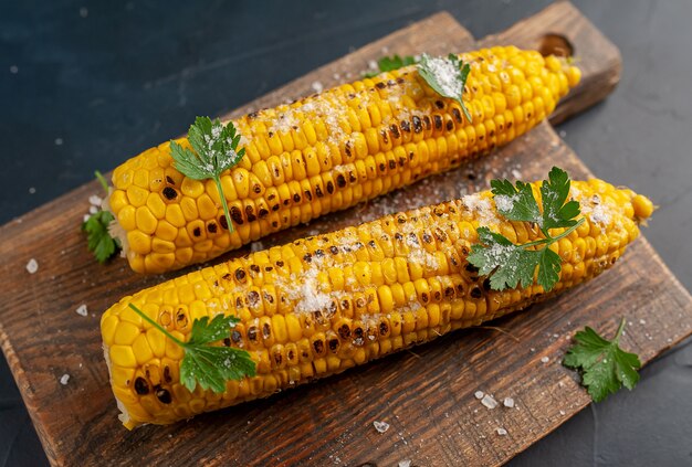 Mais alla griglia con verdure e sale sullo sfondo di cemento, snack o cena, colazione con copia spazio per il testo