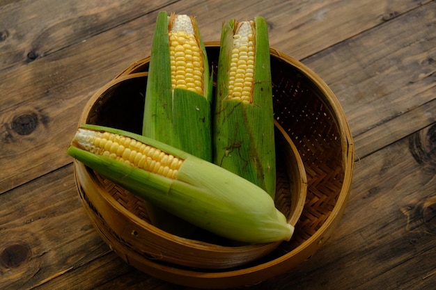 Mais dolce, chiamato anche mais da zucchero e mais polare. mais dolce crudo in un contenitore di bambù intrecciato.