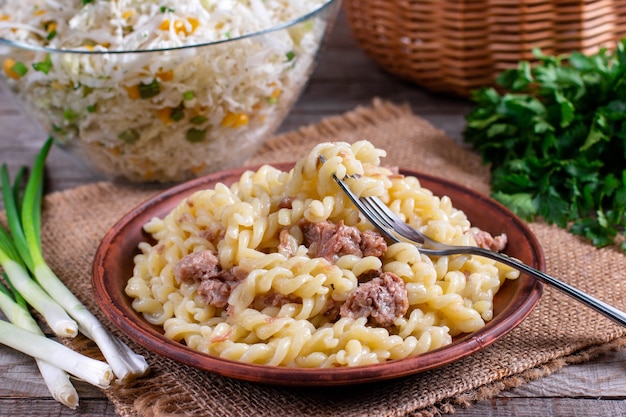 Makaroni po-flotski. Pasta alla marinara con carne macinata su un piatto su un tavolo di legno