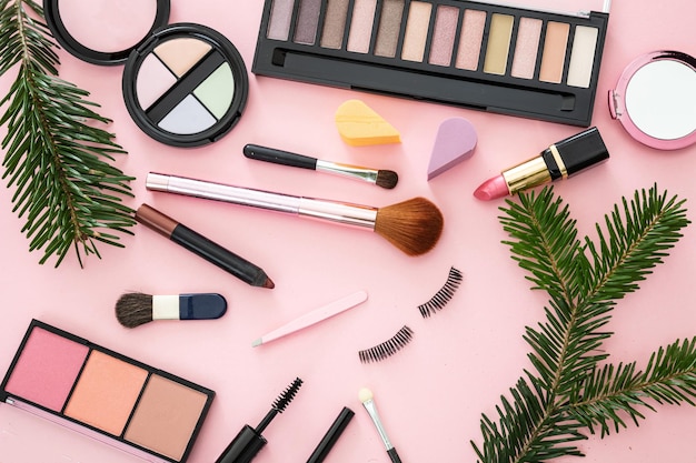 Make-up per i prodotti cosmetici di Natale su uno sfondo rosa