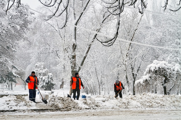 Makeevka, Ucraina - 6 febbraio 2020: i lavoratori dei servizi comunali in uniforme con le pale rimuovono la neve dopo una nevicata. Crollo del tempo. Editoriale