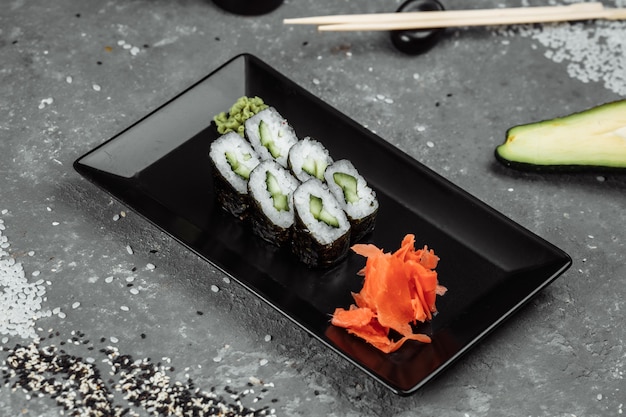 Maki con cetriolo delizioso, succoso e appetitoso. Sushi su uno sfondo grigio.