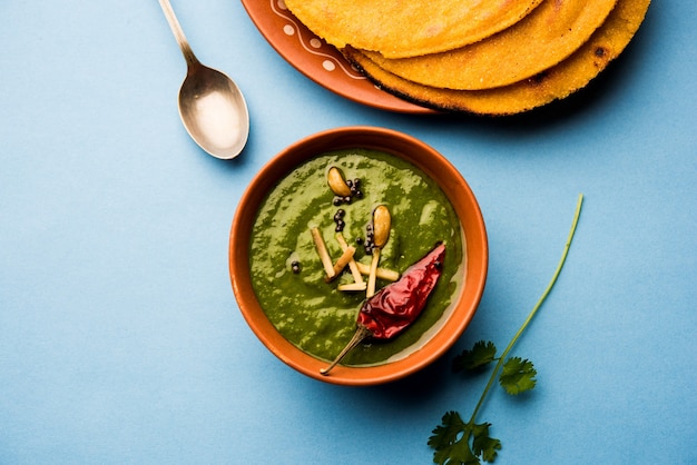 Makki di roti con sarson ka saag, popolare ricetta del piatto principale punjabi in inverno a base di pane di mais, senape e foglie di curry. servito su sfondo lunatico. messa a fuoco selettiva