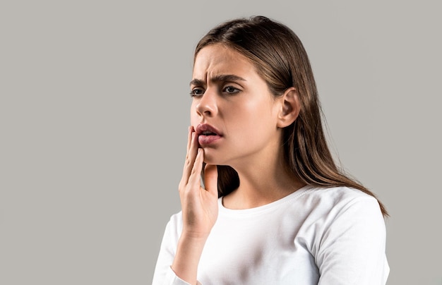 Mal di denti Donna con infezione ai denti Donna che soffre di mal di denti su sfondo grigio