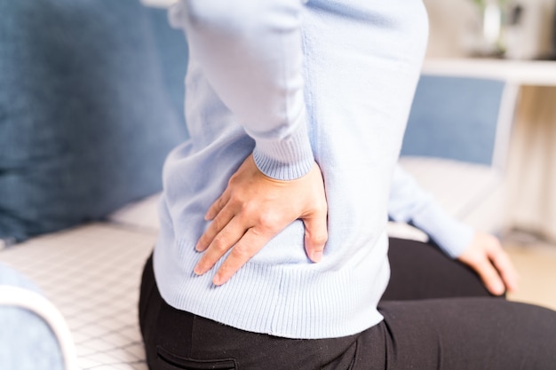 Mal di schiena a casa. le donne soffrono di mal di schiena concetto di assistenza sanitaria e medica