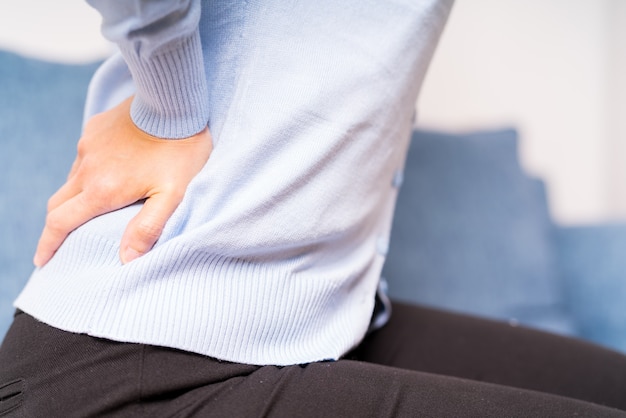 Mal di schiena a casa. le donne soffrono di mal di schiena concetto di assistenza sanitaria e medica