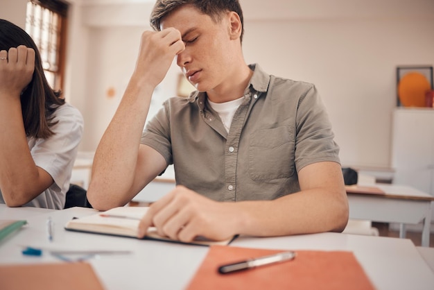 Mal di testa da stress e studente in classe con ansia rischio per la salute mentale ed esaurimento per problemi di istruzione e apprendimento Stanchezza e depressione dell'adolescente a scuola o alla scrivania del college