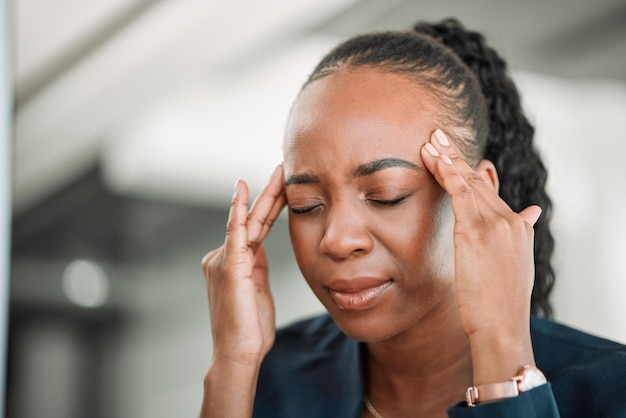 Mal di testa da stress o donna nera in ufficio con mal di testa a causa di esaurimento o stanchezza a causa della scadenza crisi di emicrania o stanca consulente femminile africana depressa o frustrata dall'ansia sul posto di lavoro