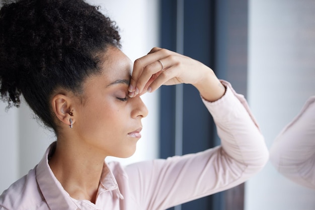 Mal di testa stress e burnout donna di colore in ufficio che si sente stanca esausta o affaticata Ansia depressione e donna d'affari con problemi di salute mentale emicrania o stressata da sola sul posto di lavoro aziendale