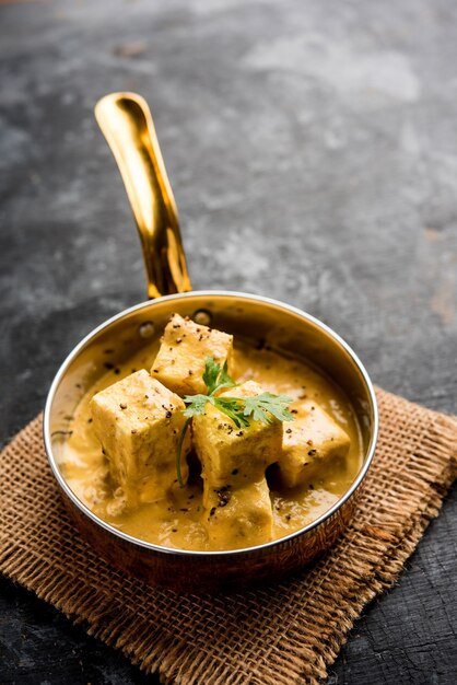 Malai o achari Paneer in un sugo fatto con panna da montare. servito su un piatto da portata. messa a fuoco selettiva