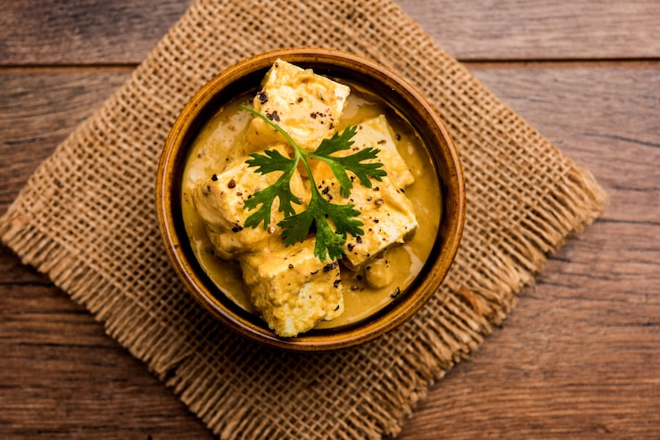 Foto malai o achari paneer in un sugo fatto con panna da montare. servito su un piatto da portata. messa a fuoco selettiva