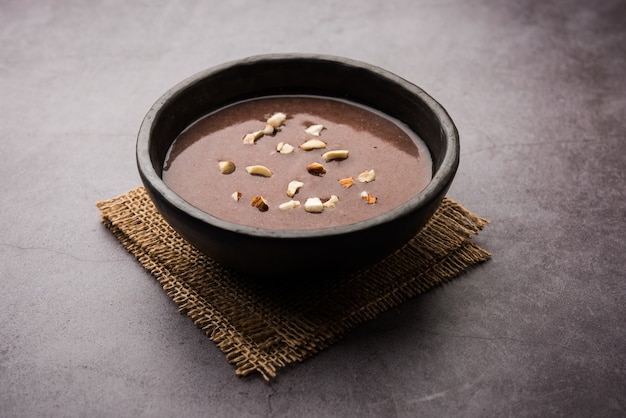 Malto Ragi Dolce o Porridge Ragi Sano in una ciotola guarnito con frutta secca frantumata