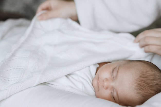 mamma amorevole che si prende cura del suo neonato a casa Il bambino sta riposando a letto