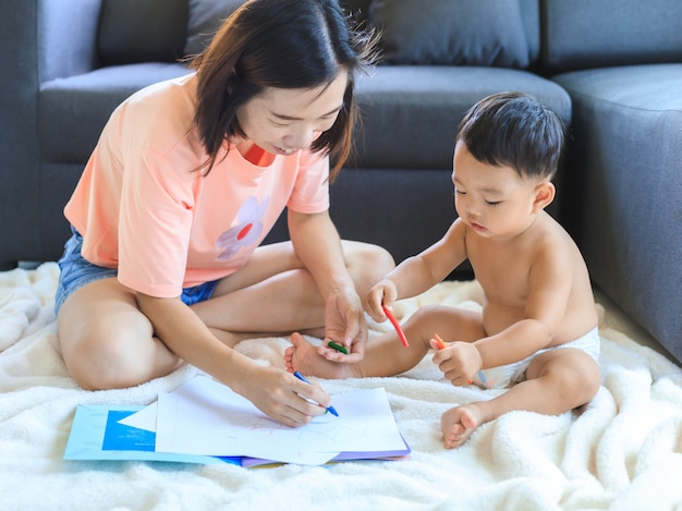 Mamma asiatica che insegna al suo tiraggio del neonato