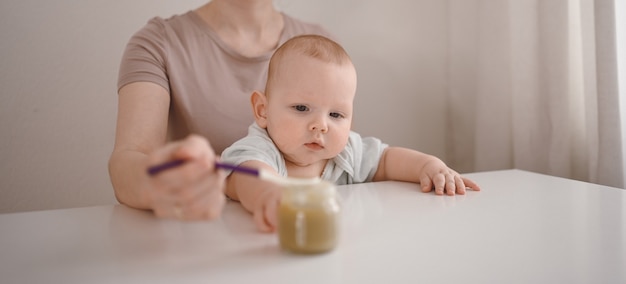 Mamma che dà la purea a un neonato.