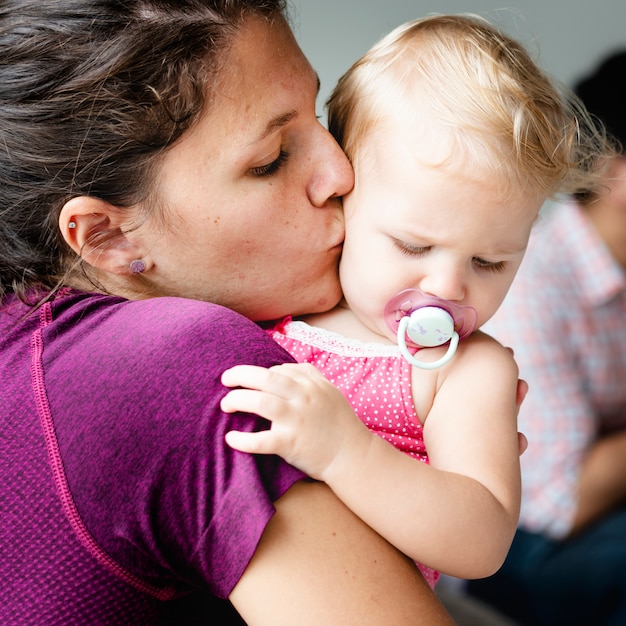 Mamma che dà un bacio a sua figlia