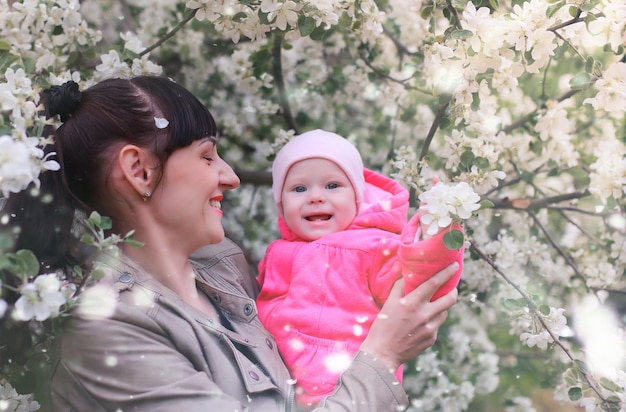 Mamma con bambino nel giardino delle mele