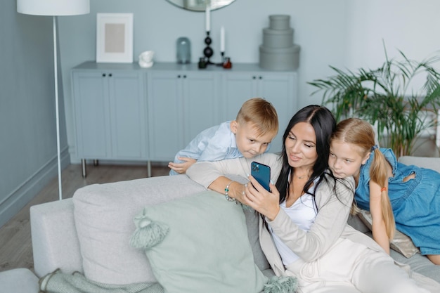Mamma con due bambini che guardano video sul suo smartphone