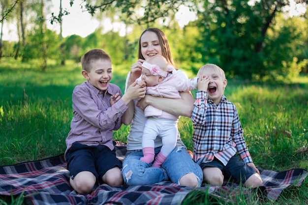 Mamma con due figli e figlia al pic-nic Tre figli e la madre sulla natura Grande famiglia