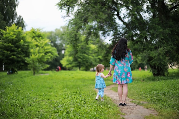 Mamma con due figlie gemelle a spasso nel parco