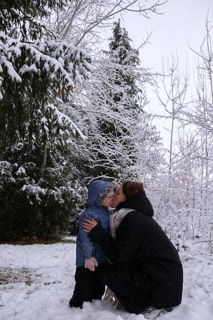 Mamma con figlia nella foresta innevata invernale