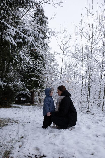 Mamma con figlia nella foresta innevata invernale