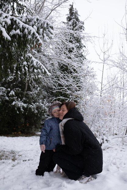 Mamma con figlia nella foresta innevata invernale