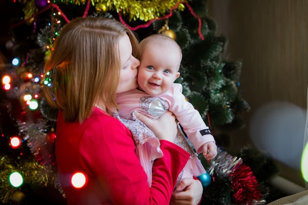 mamma con il suo bambino con un albero di natale