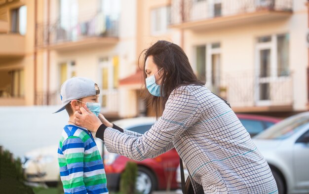 Mamma con un figlio in una mascherina medica