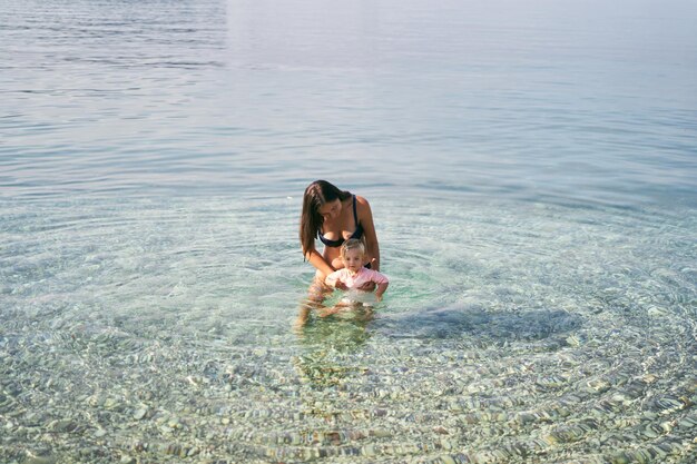 Mamma con una bambina in mare sulle secche