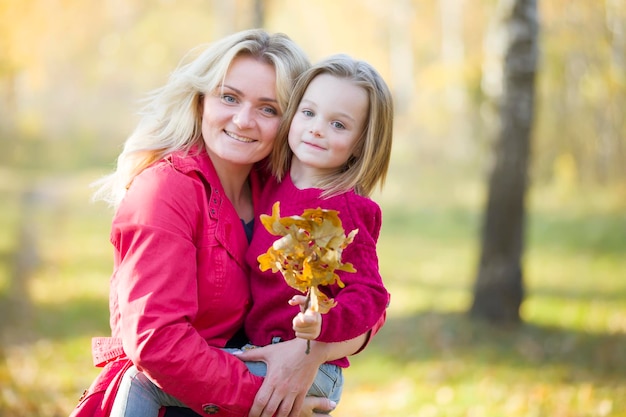 Mamma con una figlia per una passeggiata nel parco autunnale