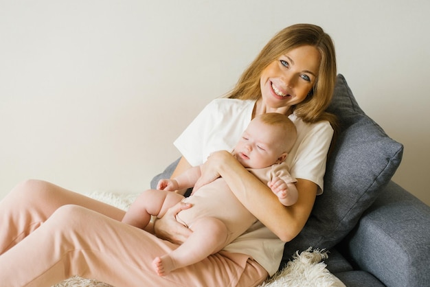 Mamma di famiglia felice e suo figlio sono seduti sul divano e sorridono