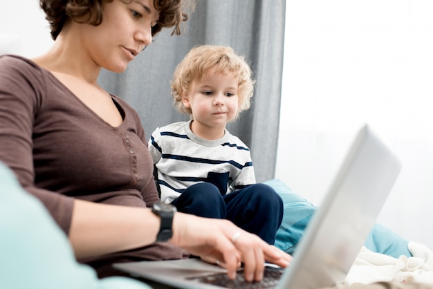 Mamma di sorveglianza di Little Boy che per mezzo del computer portatile