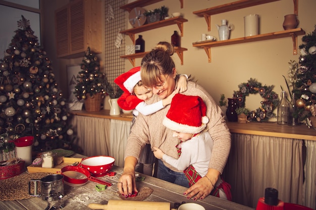 Mamma e bambini preparano i biscotti in cucina