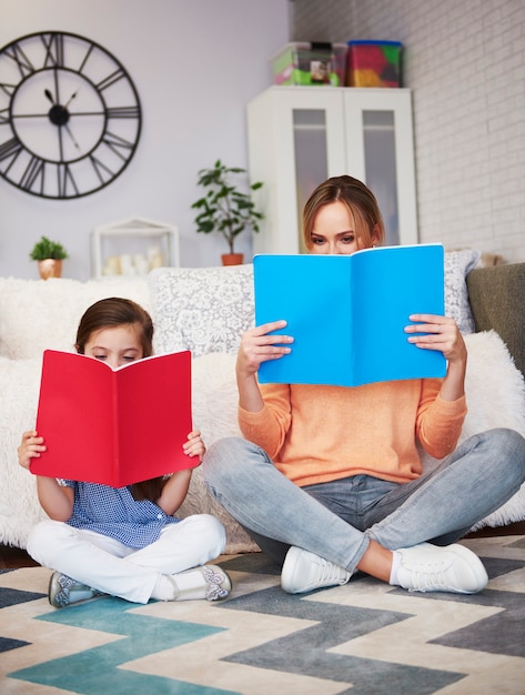 Mamma e bambino che leggono un libro in soggiorno