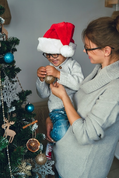 Mamma e bambino decorano insieme l'albero di Natale