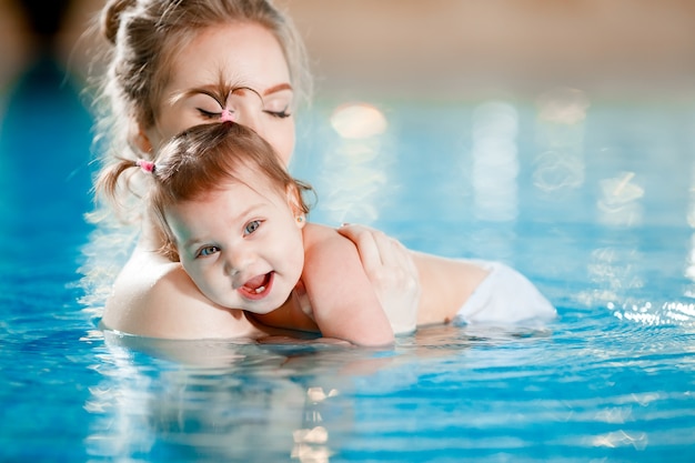 Mamma e bambino nuotano in piscina.