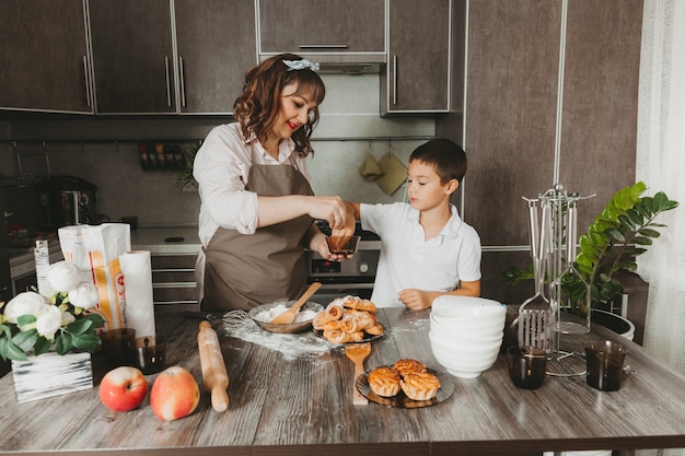 Mamma e bambino preparano una torta di compleanno in cucina per la festa della mamma, una serie di immagini dello stile di vita quotidiano all'interno della vita reale