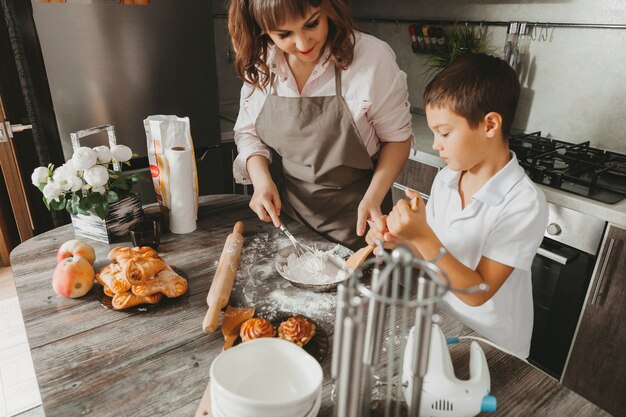 Mamma e bambino preparano una torta di compleanno in cucina per la festa della mamma, una serie di immagini dello stile di vita quotidiano all'interno della vita reale