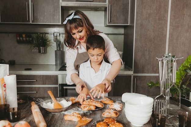 Mamma e bambino preparano una torta di compleanno in cucina per la festa della mamma, una serie di immagini dello stile di vita quotidiano all'interno della vita reale