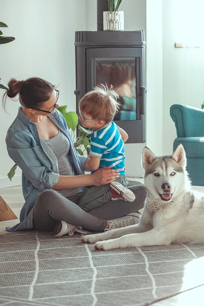 Mamma e bambino si divertono e giocano con il cane a casa