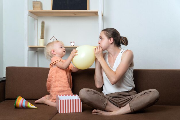 Mamma e bambino si stanno preparando per le vacanze La mamma gonfia il palloncino e il bambino aiuta