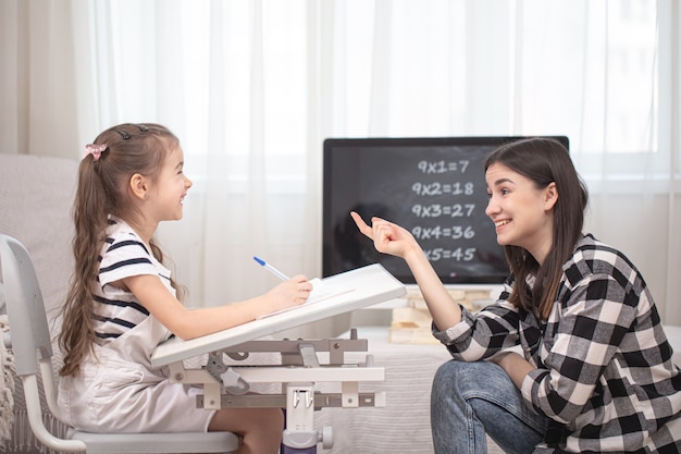 Mamma e bambino stanno facendo i compiti con la matematica. Istruzione domestica e concetto di istruzione.