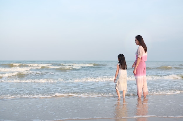 Mamma e figlia asiatiche sulla spiaggia del mare in vacanza