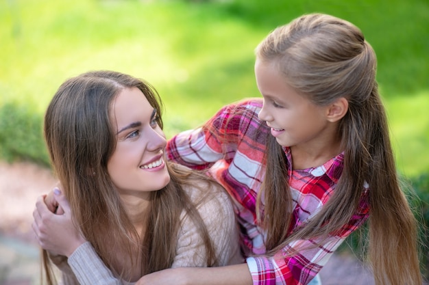 Mamma e figlia che camminano lungo la strada con le borse della spesa